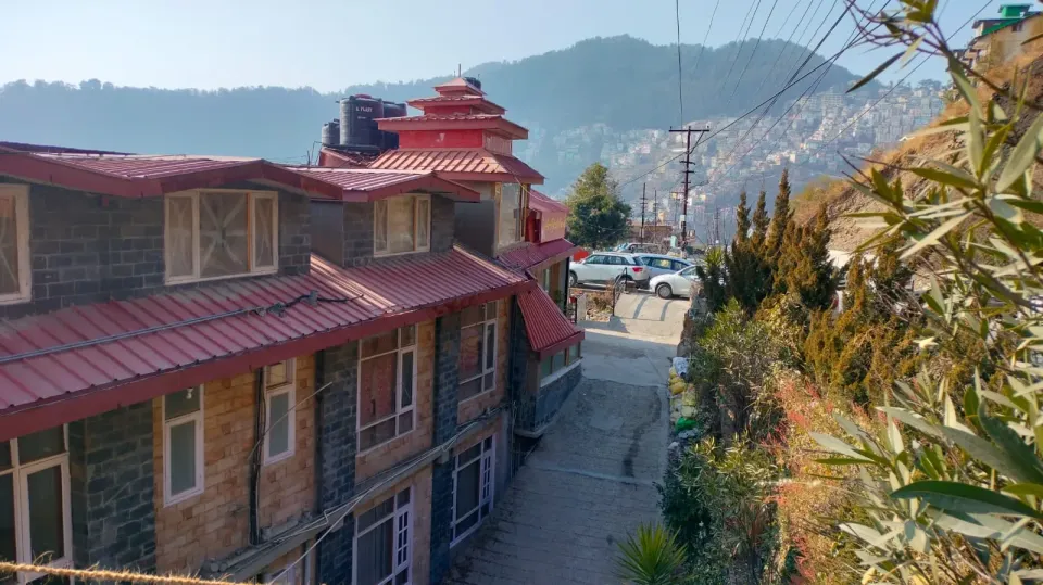Him Star View building with red roofs and the Shimla hills behind