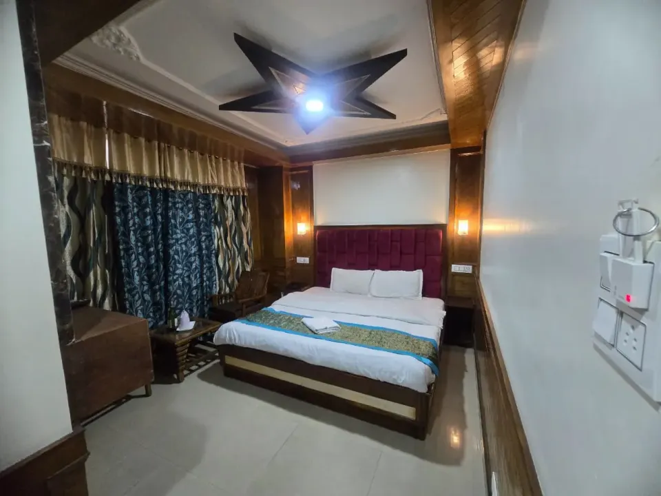 Wood-panelled deluxe room with a star-shaped ceiling and maroon headboard