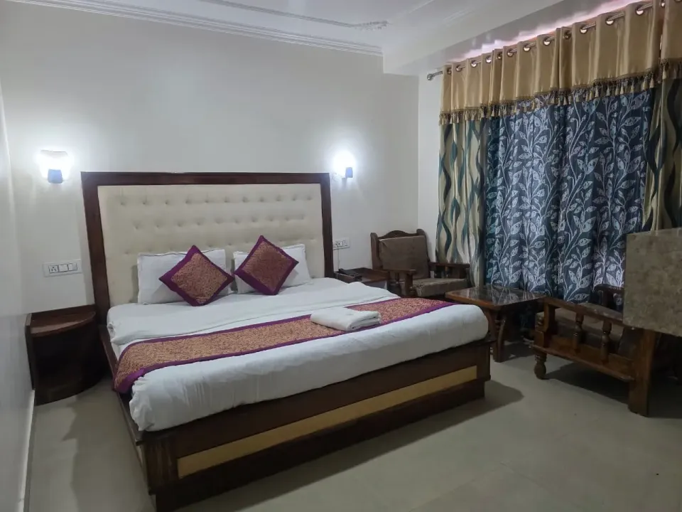 Standard room with a double bed, purple cushions and bedside lamps