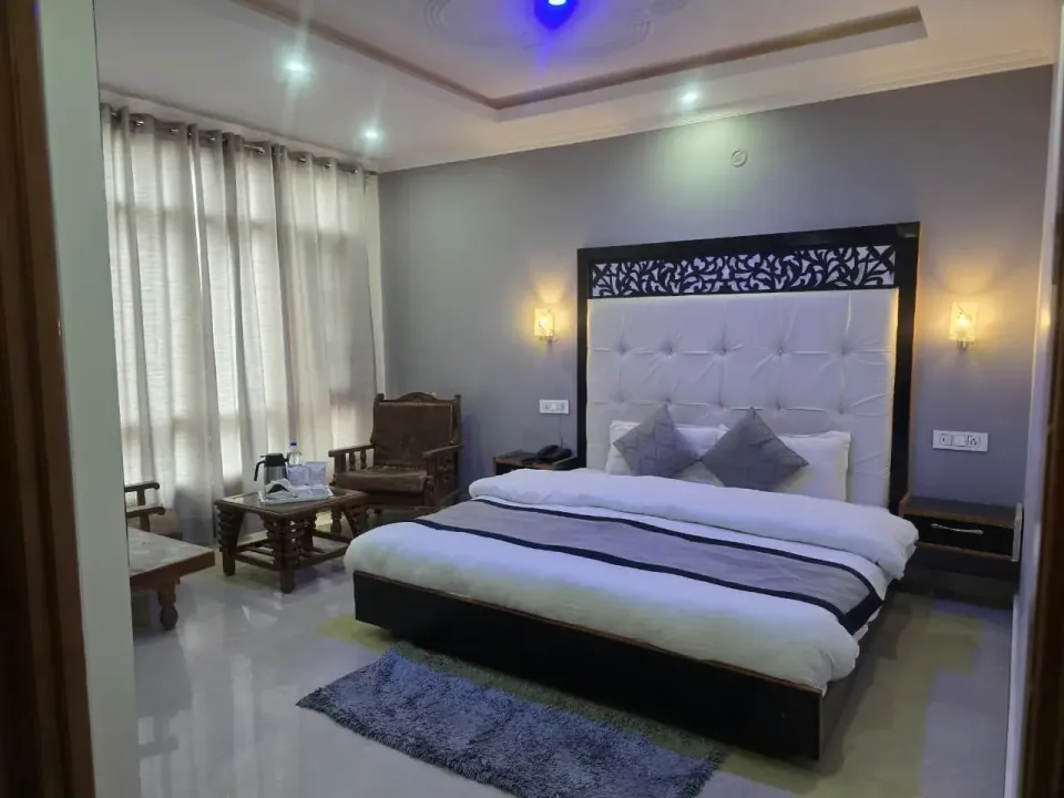 Premium room with a white tufted headboard and carved black jali panel