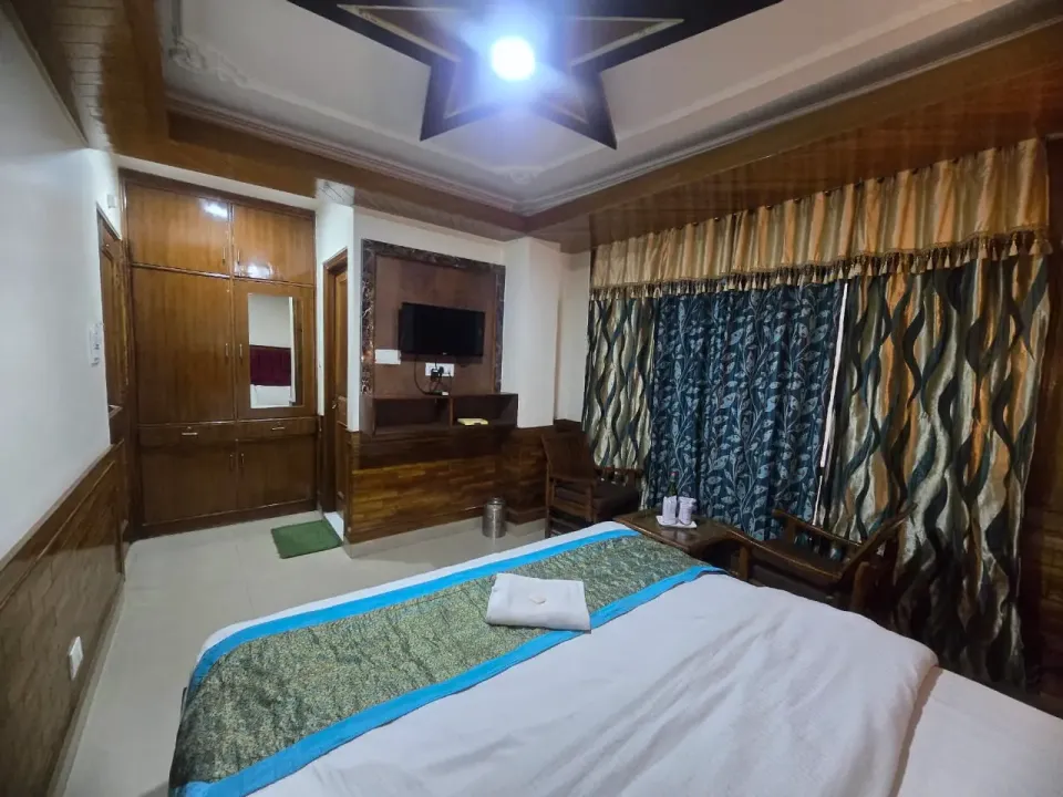 Wooden room with a star-shaped ceiling, wall-mounted TV and large wardrobe